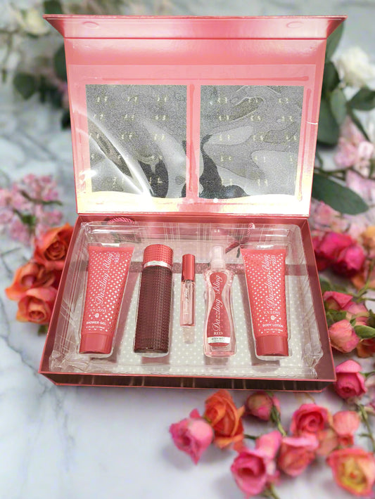 Set of red cosmetic products in a clear plastic case on a textured black surface