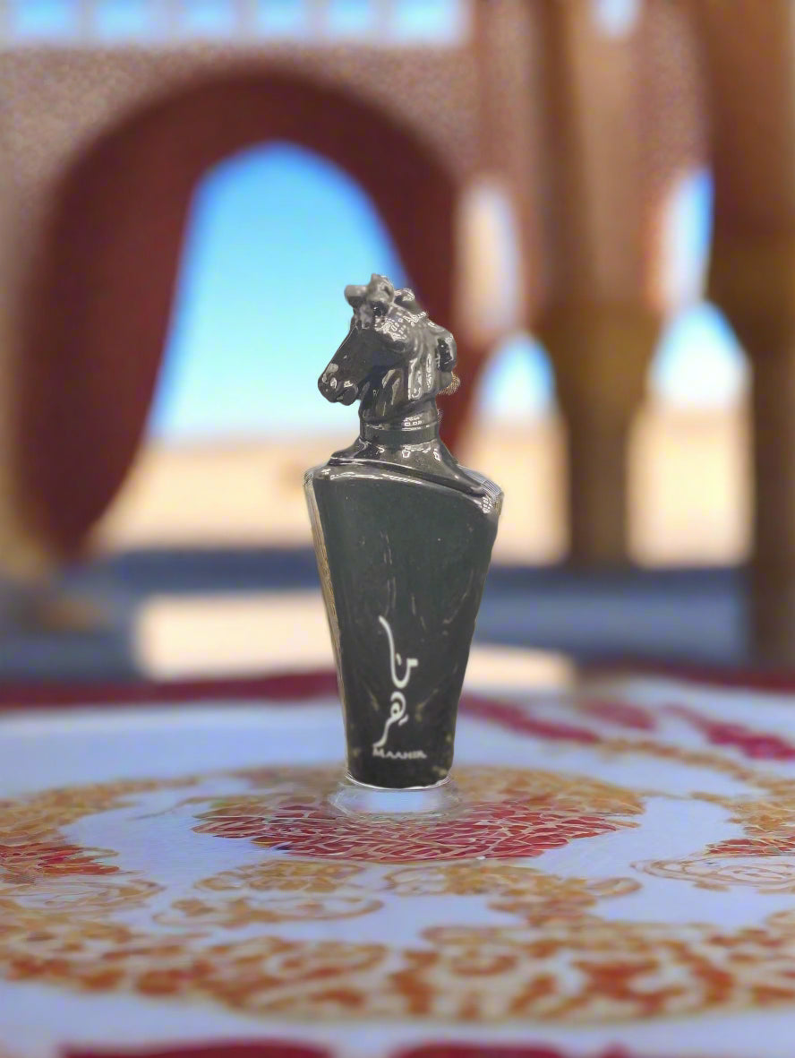 Black perfume bottle with silver cap on a textured surface