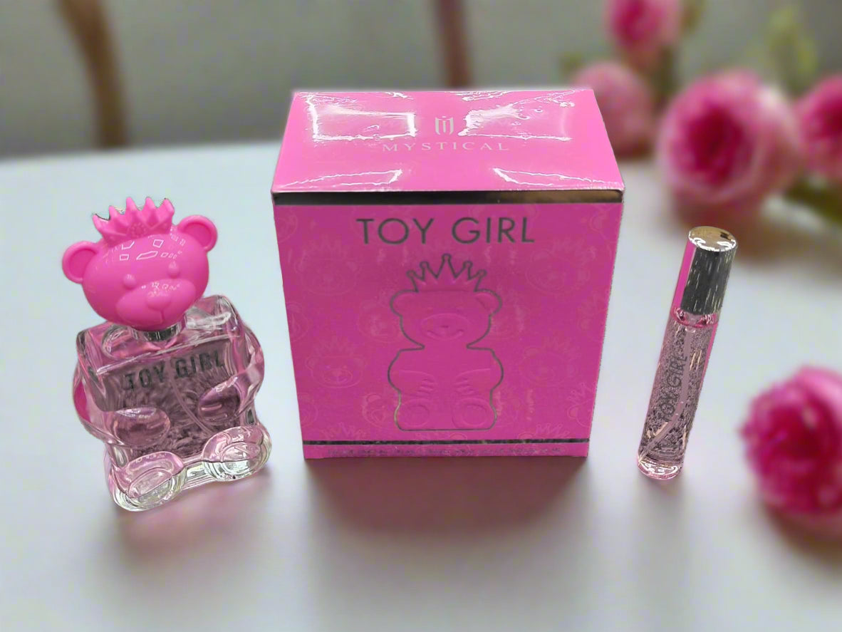 Pink perfume bottle and packaging labeled 'Toy Girl' on a textured surface