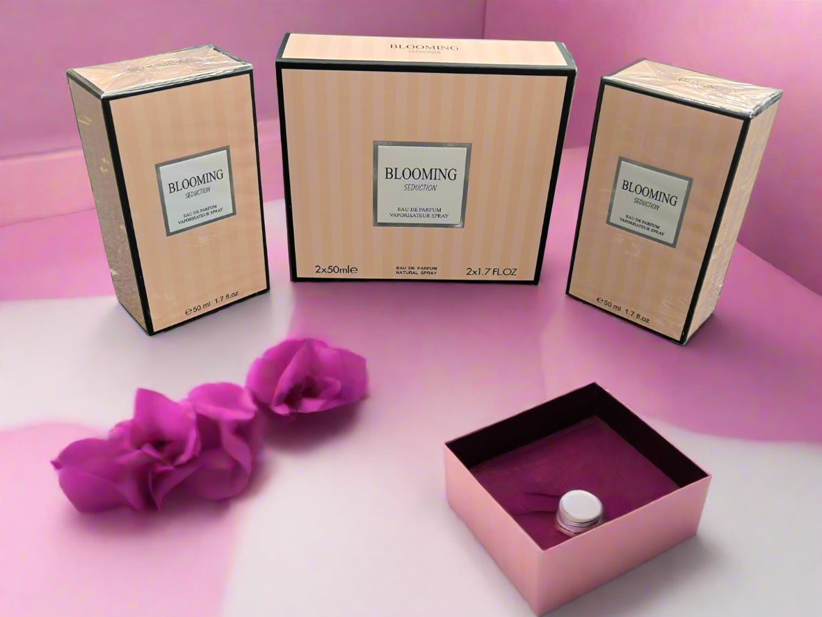 Three boxes of 'BLOOMING' perfume on a textured surface