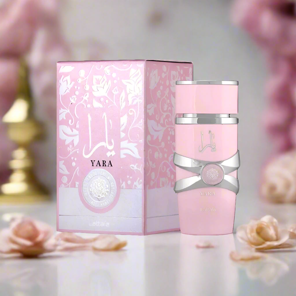 Pink perfume bottle with silver accents and matching box on a white background