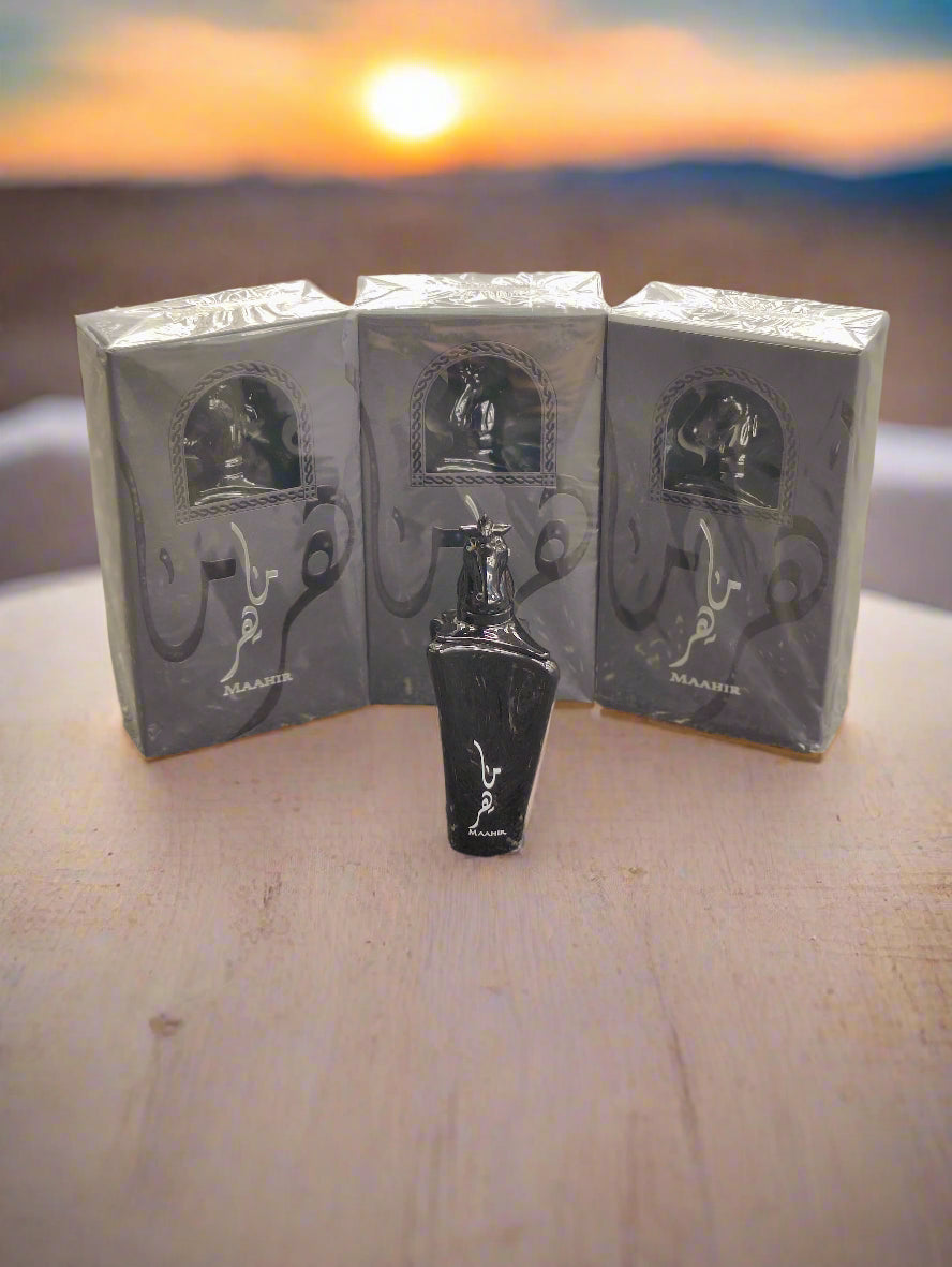 Black perfume bottle with packaging on a textured gray surface