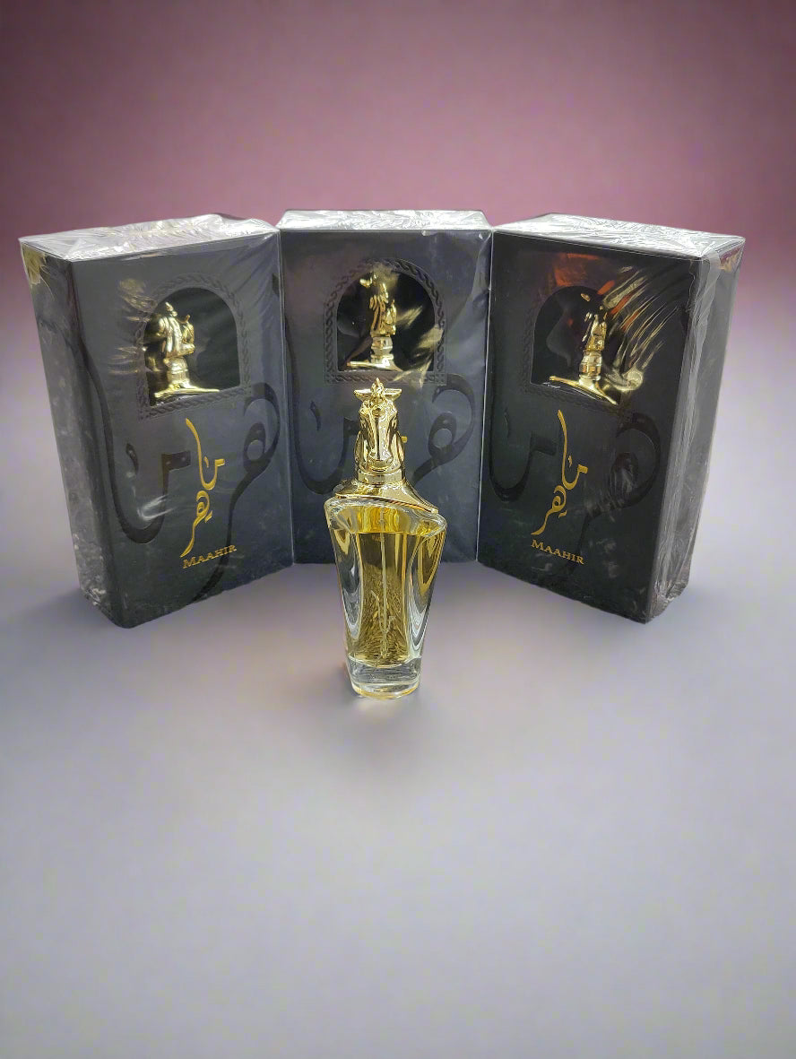 Gold perfume bottle with black packaging on a gray floor