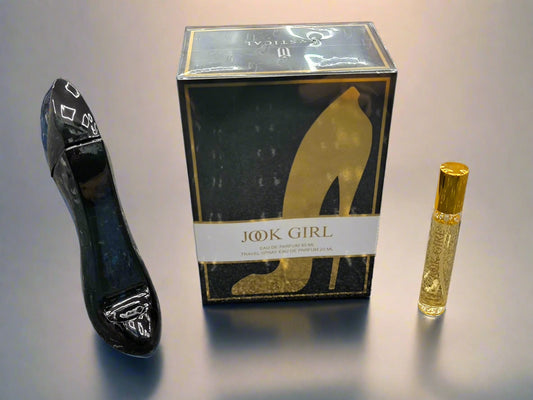 Black high-heeled shoe, 'Jook Girl' box, and gold perfume bottle on a textured surface