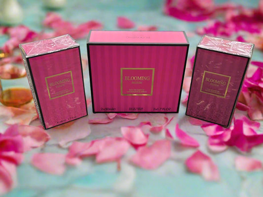 Three pink 'Blooming' perfume boxes on a textured surface