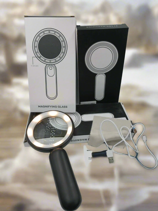 Handheld magnifying glass with packaging, cable, and user manual on a white surface.
