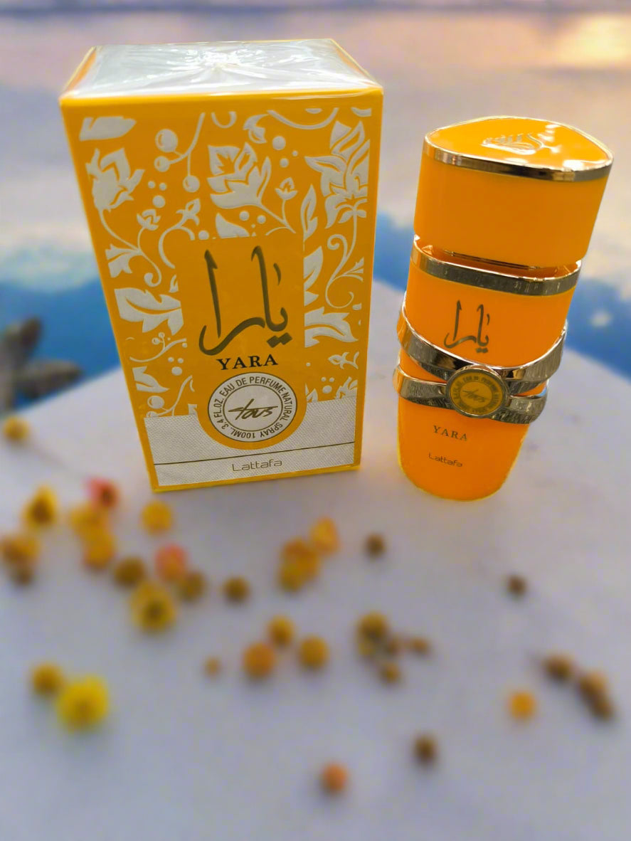 Orange Yara perfume bottle and box on a textured surface